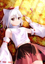 Rule 34 | 1girl, animal ears, autumn leaves, closed mouth, commentary, detached sleeves, hat, highres, holding, holding leaf, inubashiri momiji, leaf, looking at viewer, lying, multicolored clothes, multicolored skirt, navel, on back, pom pom (clothes), red hat, ribbon-trimmed sleeves, ribbon trim, skirt, smile, solo, tokin hat, touhou, urochii (ju2ti6jgpt), white hair, wolf ears