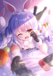 Rule 34 | 1girl, animal ear fluff, animal ears, bare shoulders, bed sheet, black gloves, black leotard, black pantyhose, blue hair, blurry, blurry background, blurry foreground, blush, braid, commentary request, controller, depth of field, don-chan (usada pekora), dualshock, fukemachi, fur-trimmed gloves, fur trim, game controller, gamepad, gloves, hair between eyes, hand up, highres, holding, hololive, legs up, leotard, long hair, lying, multicolored hair, nintendo switch, on stomach, open mouth, pantyhose, playstation controller, rabbit ears, red eyes, short eyebrows, solo, standing, strapless, strapless leotard, stuffed animal, stuffed rabbit, stuffed toy, the pose, thick eyebrows, twin braids, twintails, two-tone hair, usada pekora, usada pekora (1st costume), very long hair, virtual youtuber, wavy mouth, white hair