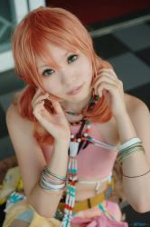 Rule 34 | 1girl, beads, belt, bracelet, cosplay, female focus, final fantasy, final fantasy xiii, jewelry, looking at viewer, midriff, necklace, oerba dia vanille, oerba dia vanille (cosplay), pink shirt, shirt, sitting, solo, twintails