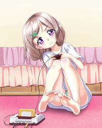 Rule 34 | 1girl, bare legs, barefoot, blush, brown hair, clover hair ornament, collarbone, controller, famicom, feet, game console, hair ornament, highres, legs, long hair, playing games, purple eyes, shirt, shuiyue fengnan, soles, solo, t-shirt, toes, wavy mouth