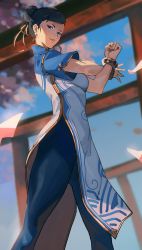 Rule 34 | 1girl, absurdres, black eyes, black hair, blue dress, blue leggings, bracelet, breasts, capcom, cherry blossoms, china dress, chinese clothes, chun-li, double bun, dress, hair bun, highres, jewelry, leggings, lips, looking at viewer, medium breasts, petals, shizu (shizuillust), sky, solo, street fighter, street fighter 6, stretching, thighs, torii