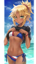 Rule 34 | 1girl, :p, bikini, black shirt, blonde hair, blue bikini, blue sky, blush, braid, breasts, clothes lift, cloud, commentary, cowboy shot, dark-skinned female, dark skin, day, english commentary, fate/grand order, fate (series), french braid, highres, looking at viewer, mordred (fate), mordred (fate) (all), mordred (fate/apocrypha), mordred (swimsuit rider) (fate), navel, ocean, outdoors, parted bangs, ponytail, shirt, shirt lift, short hair, short sleeves, side-tie bikini bottom, sky, small breasts, solo, standing, swimsuit, tan, tonee, tongue, tongue out, wet