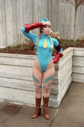 Rule 34 | 1girl, absurdres, blonde hair, boots, braid, cameltoe, cammy white, cammy white (cosplay), capcom, cosplay, highres, leotard, looking at viewer, photo (medium), salute, solo, standing, street fighter, tagme