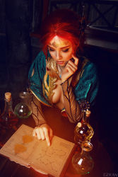 Rule 34 | 1girl, blurry, book, braid, breasts, center opening, circlet, cosplay, costume, depth of field, dress, eyeliner, eyeshadow, flask, freckles, from above, helly von valentine (disharmonica), highres, indoors, jewelry, makeup, medium breasts, necklace, no bra, parted lips, pendant, photo (medium), readiing, red hair, robe, side braids, sitting, solo, table, the witcher (series), triss merigold, triss merigold (cosplay), upper body