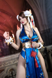 Rule 34 | 1girl, alternate costume, argentine (nationality), ass, bare hips, bare legs, bare shoulders, blue dress, blue eyes, bracelet, braid, breasts, brown hair, capcom, chun-li, chun-li (cosplay), cleavage, clenched hands, cosplay, curvy, double bun, dress, fighting stance, fingernails, hair bun, highres, jewelry, large breasts, leotard, leotard under clothes, lips, lipstick, long hair, makeup, medium breasts, no bra, pelvic curtain, photo (medium), revealing clothes, shiny clothes, short dress, simple background, smile, sophie valentine, spiked bracelet, spikes, standing, street fighter, thick thighs, thighs, wide hips