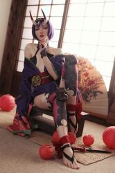 Rule 34 | 1girl, artist request, bare shoulders, cosplay, day, fate/grand order, fate (series), feet, female focus, highres, horns, indoors, looking at viewer, photo (medium), purple eyes, purple hair, short hair, shuten douji (fate), shuten douji (fate) (cosplay), sitting, skin-covered horns, solo, toes