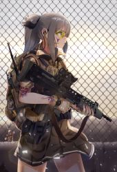 Rule 34 | 1girl, assault rifle, backpack, bag, bag charm, black skirt, brown gloves, bullpup, carbine, casino (casinoep), chain-link fence, charm (object), closed mouth, commentary request, cowboy shot, fence, fingerless gloves, from behind, gloves, goggles, grey hair, gun, headset, highres, holding, holding gun, holding weapon, l85, lens flare, load bearing vest, long hair, machine gun, military, original, outdoors, pleated skirt, ponytail, profile, revision, rifle, sa80, scope, short sleeves, sidelocks, skirt, solo, squad automatic weapon, tattoo, trigger discipline, weapon, yellow eyes