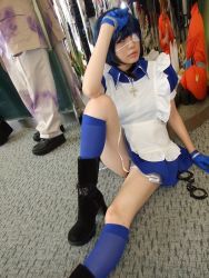 Rule 34 | 1girl, apron, asian, black footwear, blue eyes, blue gloves, blue hair, blue socks, boots, collar, color contacts, cosplay, cross, cuffs, dutch angle, eyepatch, gloves, handcuffs, high heels, ikkitousen, indoors, kneehighs, looking at viewer, maid, maid apron, namada, on floor, photo (medium), puffy short sleeves, puffy sleeves, reflection, ryomou shimei, ryomou shimei (cosplay), short sleeves, sitting, socks, solo focus