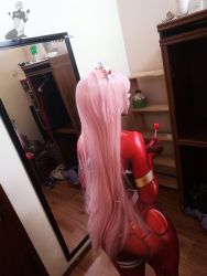 Rule 34 | 1boy, absurdres, androgynous, ass, bed, bodysuit, candy, cosplay, darkwaifutrap, darling in the franxx, food, from behind, highres, huge ass, long hair, looking away, mirror, photo (medium), pink hair, red bodysuit, skin tight, solo, standing, trap, zero two (darling in the franxx), zero two (darling in the franxx) (cosplay)