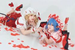 Rule 34 | 0 ayanami, 2girls, bat wings, blonde hair, blue hair, closed mouth, cosplay photo, flandre scarlet, full body, hair between eyes, hat, highres, interlocked fingers, light smile, looking at viewer, lying, medium hair, mob cap, multicolored wings, multiple girls, nail polish, on ground, on stomach, photo (medium), pink headwear, pink shirt, pink skirt, pointy ears, puffy short sleeves, puffy sleeves, red eyes, red footwear, red nails, red petals, red skirt, red vest, remilia scarlet, shirt, short sleeves, simple background, skirt, socks, the pose, touhou, vest, white background, white headwear, white shirt, white socks, wings, wrist cuffs
