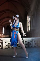 Rule 34 | 1girl, alternate costume, argentine (nationality), ass, bare hips, bare legs, bare shoulders, blue dress, blue eyes, bracelet, braid, breasts, brown hair, capcom, chun-li, chun-li (cosplay), cleavage, cosplay, curvy, double bun, dress, fingernails, full body, hair bun, highres, jewelry, large breasts, leotard, leotard under clothes, lips, lipstick, long hair, looking at viewer, makeup, medium breasts, no bra, pelvic curtain, photo (medium), revealing clothes, shiny clothes, short dress, simple background, smile, sophie valentine, spiked bracelet, spikes, standing, street fighter, street fighter iv (series), thick thighs, thighs, v, wide hips