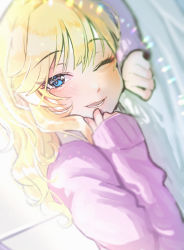 1girl blonde_hair blue_eyes blurry blurry_foreground blush commentary_request depth_of_field fujima_(k114) highres idolmaster idolmaster_cinderella_girls long_hair long_sleeves lower_teeth_only lying ohtsuki_yui on_stomach one_eye_closed purple_sweater smile solo sweater teeth upper_body