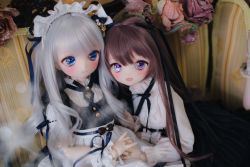 Rule 34 | 2girls, black ribbon, black skirt, blue eyes, blush, brooch, brown hair, doll, doll joints, fangs, flower, frilled hairband, frilled shirt, frills, grey hair, hair ribbon, hairband, high-waist skirt, highres, holding hands, jewelry, joints, lolita fashion, long hair, long sleeves, looking at another, looking at viewer, multiple girls, neck ribbon, noeri (shake 2727), open mouth, original, photo (medium), purple eyes, ribbon, ring, rose, shirt, short sleeves, skirt, smile, upper body, white shirt, wrist cuffs