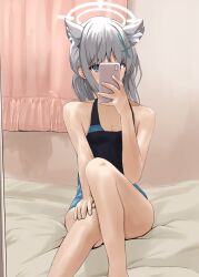 Rule 34 | 1girl, absurdres, animal ear fluff, animal ears, bare arms, black one-piece swimsuit, blue archive, blue one-piece swimsuit, cellphone, competition swimsuit, cross hair ornament, disuto, feet out of frame, grey eyes, grey hair, hair ornament, halo, highres, holding, holding phone, indoors, knee up, looking at viewer, medium hair, one-piece swimsuit, phone, selfie, shiroko (blue archive), shiroko (swimsuit) (blue archive), sitting, smartphone, solo, swimsuit, two-tone swimsuit, wolf ears