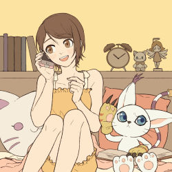 Rule 34 | 1girl, :d, bare shoulders, blue eyes, blush, book, brown background, brown hair, chunri (cat795812), collarbone, digimon, digimon (creature), digimon adventure: last evolution kizuna, figure, happy, highres, holding, knees up, open book, open mouth, pajamas, phone, pillow, short hair, shorts, sitting, smile, solo, tail, tailmon, talking on phone, teeth, upper teeth only, yagami hikari