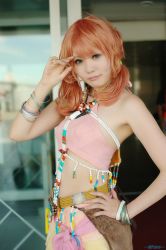 Rule 34 | 1girl, belt, bracelet, cosplay, female focus, final fantasy, final fantasy xiii, hand on own hip, hip focus, jewelry, looking at viewer, midriff, necklace, oerba dia vanille, oerba dia vanille (cosplay), pink shirt, shirt, skirt, solo, standing, twintails