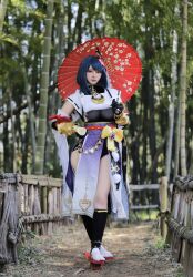 Rule 34 | 1girl, absurdres, bamboo, bamboo forest, black gloves, black shorts, blue hair, blurry, blurry background, bodystocking, bow, breasts, brown eyes, cosplay photo, forest, genshin impact, geta, gloves, highres, holding, holding umbrella, kujou sara, long skirt, looking at viewer, mask, mask on head, medium breasts, medium hair, nature, nueyama nueccha, photo (medium), purple skirt, shorts, skirt, smile, solo, umbrella, vision (genshin impact), yellow bow