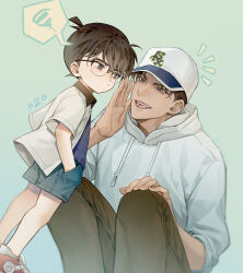 Rule 34 | 2boys, black hair, commentary request, edogawa conan, glasses, green background, hair between eyes, hands in pockets, hat, hattori heiji, hood, hoodie, looking at another, meitantei conan, multiple boys, notice lines, numbered, shorts, simple background, sleeves rolled up, smile, spoken squiggle, squatting, squiggle, yoshicha