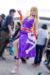 Rule 34 | 1girl, blonde hair, cosplay, dress, fatal fury, garou: mark of the wolves, gloves, high heels, highres, jenet behrn, jenet behrn (cosplay), long hair, miyy my, photo (medium), real life, skull print, sleeveless, standing, standing on one leg, the king of fighters