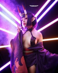 Rule 34 | 1girl, breasts, cosplay, fate/grand order, fate (series), female focus, highres, horns, indoors, looking at viewer, medium breasts, mexican (nationality), photo (medium), pointy ears, purple eyes, purple hair, ruby blossom, short hair, shuten douji (fate), skin-covered horns, solo