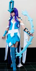 Rule 34 | 1girl, blue dress, boots, bow (weapon), cleavage cutout, clothing cutout, cosplay, creatures (company), dress, game freak, gen 2 pokemon, holding, holding weapon, legendary pokemon, looking to the side, nintendo, personification, photo (medium), pokemon, purple hair, solo, standing, suicune, thigh boots, thighhighs, weapon