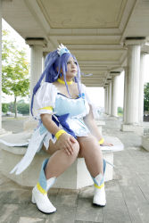 Rule 34 | 1girl, ankle boots, asian, blue eyes, blue hair, boots, bow, bracelet, breasts, choker, chouzuki maryou, cosplay, cure diamond, cure diamond (cosplay), dokidoki! precure, dress, headpiece, highres, jewelry, large breasts, long hair, magical girl, matching hair/eyes, photo (medium), plump, ponytail, precure, puffy short sleeves, puffy sleeves, ribbon, short sleeves, sitting, solo, tiara