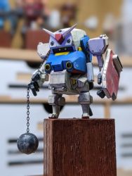 Rule 34 | ball and chain (weapon), blurry, blurry background, cavico models, fusion, gundam, highres, jgsdf type 07 tank natchin, looking ahead, matage sanjuro, mecha, mobile suit gundam, model kit, model kit (medium), no humans, open hands, photo (medium), robot, rx-78-2, shield, unconventional media, v-fin, yellow eyes