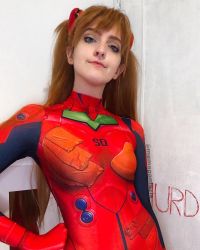 Rule 34 | 1girl, blue eyes, bodysuit, brazilian (nationality), breasts, brown hair, cosplay, evangelion: 3.0 you can (not) redo, hairpods, hand on own hip, highres, interface headset, lips, looking at viewer, medium breasts, memepantazis, neon genesis evangelion, photo (medium), plugsuit, rebuild of evangelion, red bodysuit, shiny clothes, smile, solo, souryuu asuka langley, souryuu asuka langley (cosplay), standing, twintails, twitter username, two side up, wide hips