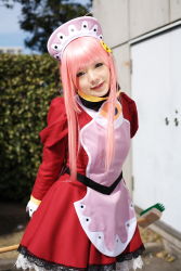 Rule 34 | 1girl, apron, asian, blurry, breasts, broom, cosplay, cowboy shot, depth of field, dress, head tilt, hedge, highres, light smile, looking at viewer, maid, maid apron, makeup, mascara, namada, nono (top wo nerae 2!), outdoors, photo (medium), pink hair, puffy sleeves, sidelocks, small breasts, solo, standing, top wo nerae 2!