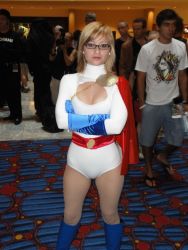 Rule 34 | 1girl, blonde hair, breasts, cape, cleavage, cosplay, dc comics, glasses, gloves, leotard, photo (medium), power girl, red cape, standing, tagme