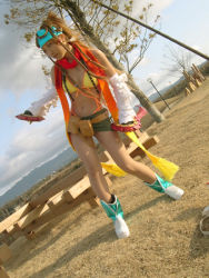 Rule 34 | 1girl, ankle boots, bandana, bare legs, belt, belt pouch, bikini, bikini top only, blonde hair, boots, braid, breasts, cleavage, closed mouth, cosplay, cosplay photo, day, detached sleeves, dual wielding, female focus, final fantasy, final fantasy x, final fantasy x-2, full body, green skirt, holding, holding weapon, jewelry, long hair, long sleeves, miniskirt, multiple braids, navel piercing, necklace, no socks, outdoors, photo (medium), piercing, plant, pouch, red scarf, rikku (ff10), scarf, skirt, small breasts, smile, solo, standing, swimsuit, sword, tree, very long hair, weapon