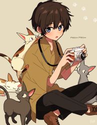 Rule 34 | 1boy, :o, animal, arisa (aren), black cat, black pants, blue eyes, brown background, brown cat, brown footwear, brown hair, brown shirt, camera, cat, collared shirt, expressionless, full body, grey cat, hands up, highres, holding, holding camera, indian style, light blush, looking at viewer, male focus, open collar, original, pants, parted lips, paw print, shirt, shoe soles, shoes, short hair, short sleeves, signature, simple background, sitting, solo, sound effects