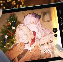 Rule 34 | 2girls, animal ears, arknights, black choker, blonde hair, blue eyes, blue nails, blurry, blurry background, brown cardigan, cardigan, cellphone, choker, christmas, christmas tree, closed mouth, collared shirt, commentary, couple, depth of field, dog ears, dog girl, earclip, fake antlers, hair between eyes, highres, holding hands, horns, joshua (shisanli934), kristen (arknights), long hair, long sleeves, looking at viewer, multiple girls, nail polish, one eye closed, orange eyes, phone, saria (arknights), selfie, shirt, sleeves past wrists, smartphone, symbol-only commentary, tongue, tongue out, upper body, viewfinder, white hair, white shirt, yuri