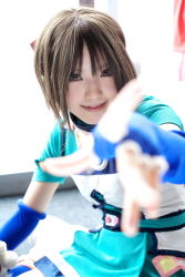 Rule 34 | 1girl, asian, blue gloves, blue legwear, blurry, breasts, brown eyes, brown hair, cosplay, depth of field, elbow gloves, fingerless gloves, gensou suikoden, gensou suikoden iii, gloves, highres, indoors, kipi-san, looking at viewer, mel, mel (cosplay), mole, outstretched arm, photo (medium), short hair, small breasts, smile