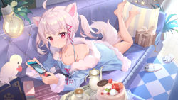 1girl, :o, absurdres, animal ears, animal slippers, bangs, bare legs, barefoot, bird, blue pajamas, box, cake, commentary request, couch, cup, cushion, eyebrows visible through hair, feet up, food, fox ears, fox girl, fox tail, fur trim, gift, gift box, hair ornament, hair tie, highres, holding, lamp, legs up, long sleeves, looking at viewer, lying, nintendo switch, on couch, on stomach, original, pajamas, pink hair, pink tail, plant, potted plant, red eyes, shoes removed, short twintails, sidelocks, slippers, solo, somna, tail, tea set, teacup, teapot, the pose, twintails, virtual youtuber