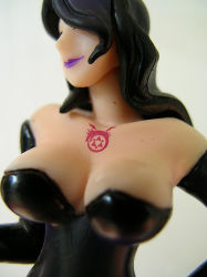 Rule 34 | 00s, 1girl, bare shoulders, black dress, black gloves, black hair, breasts, cleavage, dress, figure, fullmetal alchemist, gloves, homunculus, large breasts, lipstick, long hair, lowres, lust (fma), makeup, non-web source, ouroboros, purple lips, smile, solo, strapless, strapless dress, tattoo, wavy hair