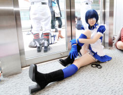 Rule 34 | 1girl, apron, asian, black footwear, blue eyes, blue gloves, blue hair, blue socks, boots, collar, color contacts, cosplay, cross, cuffs, dutch angle, eyepatch, gloves, handcuffs, high heels, hugging own legs, ikkitousen, indoors, kneehighs, looking at viewer, maid, maid apron, namada, on floor, photo (medium), puffy short sleeves, puffy sleeves, reflection, ryomou shimei, ryomou shimei (cosplay), short sleeves, sitting, socks, solo focus