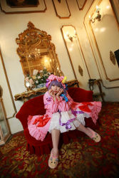 Rule 34 | 1girl, asian, bow, carpet, chandelier, cosplay, couch, crescent, dress, female focus, hat, highres, long hair, mirror, mob cap, patchouli knowledge, photo (medium), purple hair, red upholstery, ribbon, slippers, solo, table, tenshi myu, thighhighs, touhou, white dress