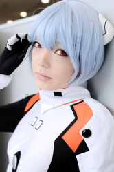 Rule 34 | 1girl, against wall, asian, ayanami rei, blue hair, color contacts, cosplay, hairpods, leaning back, looking at viewer, makeup, mascara, namada, neon genesis evangelion, photo (medium), plugsuit, plugsuit (cosplay), short hair, solo, standing