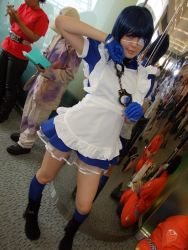 Rule 34 | 1girl, apron, asian, black footwear, blue eyes, blue gloves, blue hair, blue socks, blurry, boots, collar, color contacts, contrapposto, cosplay, cross, cuffs, depth of field, dutch angle, eyepatch, gloves, handcuffs, ikkitousen, indoors, kneehighs, looking at viewer, maid, maid apron, namada, photo (medium), puffy short sleeves, puffy sleeves, reflection, ryomou shimei, ryomou shimei (cosplay), short sleeves, socks, solo focus, standing