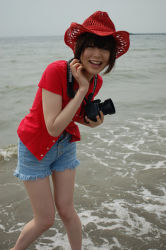 Rule 34 | 1girl, asian, bare legs, beach, black hair, bra, breasts, camera, cowboy hat, cutoffs, denim, denim shorts, happy, hat, lingerie, looking at viewer, namada, open clothes, open shirt, outdoors, photo (medium), red shirt, shirt, short hair, short sleeves, shorts, small breasts, smile, solo, standing, underwear