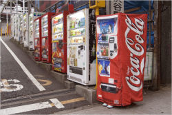 Rule 34 | asian, blue footwear, bottle, coca-cola, cosplay, cosplay photo, day, outdoors, photo (medium), real life, road, shoes, standing, street, tsukioka aya, vending machine, what