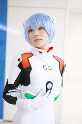 Rule 34 | 1girl, asian, ayanami rei, blue hair, breasts, color contacts, cosplay, hairpods, highres, looking up, namada, neon genesis evangelion, photo (medium), plugsuit, plugsuit (cosplay), red eyes, short hair, small breasts, solo, standing
