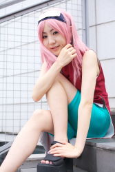 Rule 34 | 1girl, asian, bare shoulders, bike shorts, black eyes, cosplay, dress, earrings, fingernails, haruno sakura, haruno sakura (cosplay), headband, headdress, highres, jewelry, legs, looking at viewer, mole, nail polish, naruto, naruto (series), outdoors, photo (medium), pink hair, red dress, short hair, shorts, side slit, sitting, skin tight, sleeveless, sleeveless dress, smile, solo, spandex, stairs