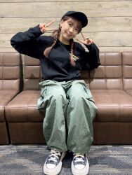 Rule 34 | 1girl, braid, couch, earrings, hat, indoors, jewelry, long hair, looking at viewer, photo (medium), saito shuka, shoes, sitting, smile, sneakers, voice actor