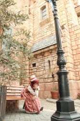 Rule 34 | 1girl, asian, bench, cosplay, cosplay photo, dress, esther blanchett, esther blanchett (cosplay), hat, kipi-san, lamppost, looking at viewer, outdoors, park bench, photo (medium), plaid, plaid skirt, puffy sleeves, red hair, road, sitting, skirt, solo, street, trinity blood