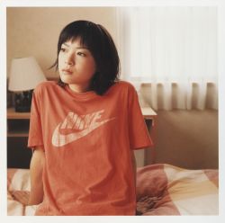 Rule 34 | 1girl, a piacere, arm support, asian, bed, bedroom, border, highres, indoors, japanese (nationality), looking away, looking to the side, nike (company), photo (medium), shirt, solo, t-shirt, ueno juri, white border