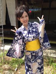 Rule 34 | 1girl, brown eyes, brown hair, day, double v, female focus, japanese (nationality), japanese clothes, kimono, looking at viewer, medium hair, mole, outdoors, photo (medium), smile, solo, standing, teeth, v, yoshikawa aimi