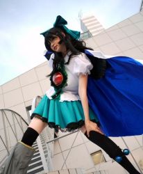 Rule 34 | 1girl, black hair, black thighhighs, bow, building, cosplay, cosplay photo, dutch angle, female focus, from below, hair bow, hand on leg, lace, long hair, looking at viewer, mari (graceful day), non-web source, photo (medium), puffy sleeves, reiuji utsuho, reiuji utsuho (cosplay), skirt, solo, thighhighs, touhou, wings, zettai ryouiki