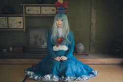 Rule 34 | 1girl, absurdres, architecture, blue dress, blue hair, blue hat, brown eyes, closed mouth, cosplay photo, dress, east asian architecture, frilled dress, frills, full body, grey hair, hat, hat tassel, highres, indoors, japanese clothes, kamishirasawa keine, light smile, long sleeves, looking at viewer, multicolored hair, nasubi iiiii, own hands together, photo (medium), red tassel, sitting, solo, tatami, tokin hat, touhou, two-tone hair